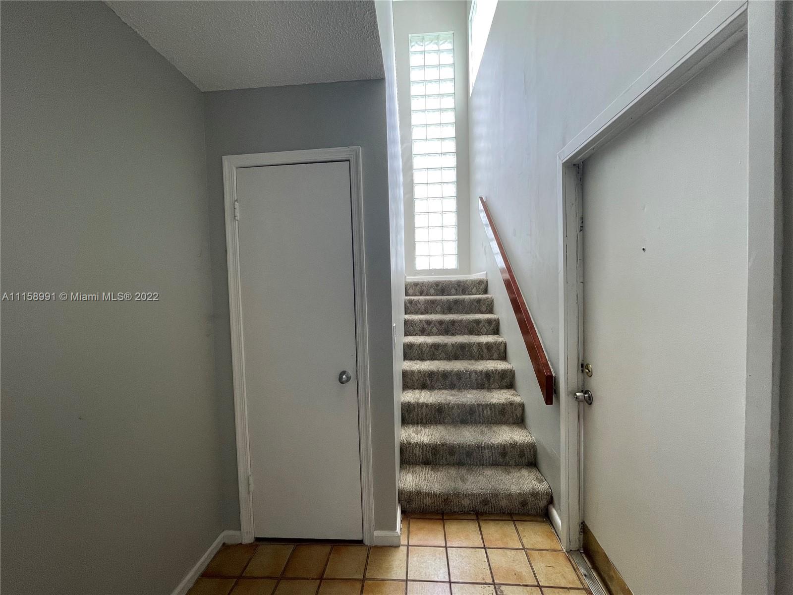 5140 Elmhurst Road, Unit H West Palm Beach, FL 33417 - Photo 8 of 15 a view of entryway with wooden floor and stairs