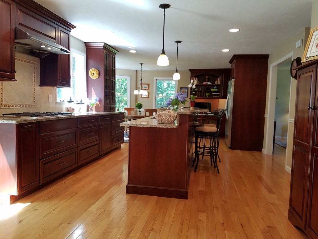 16 Cadorette Road Ashland, MA 01721 - Photo 7 of 29 a kitchen with stainless steel appliances granite countertop a refrigerator a sink dishwasher a stove and a dining table with wooden floor