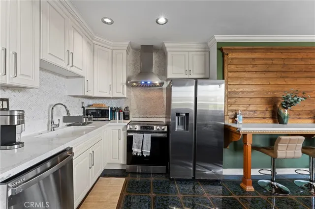 a kitchen with stainless steel appliances granite countertop a sink a stove and refrigerator