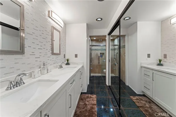 a en suite bathroom with a double vanity sink a mirror and a shower