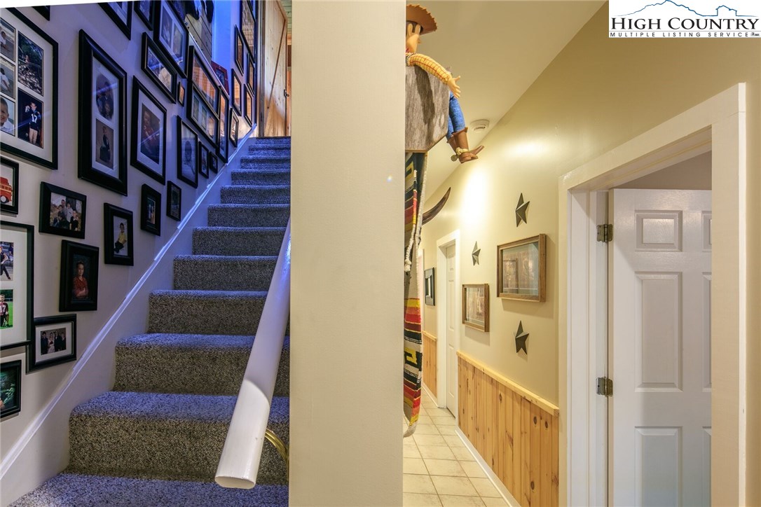 2137-2139 Little Laurel Road Creston, NC 28615 - Photo 29 of 49 a view of staircase with lots of frames on wall and a potted plant