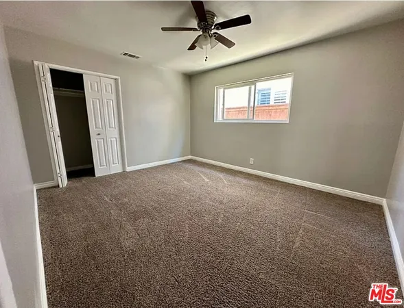 a view of a livingroom with a ceiling fan & window