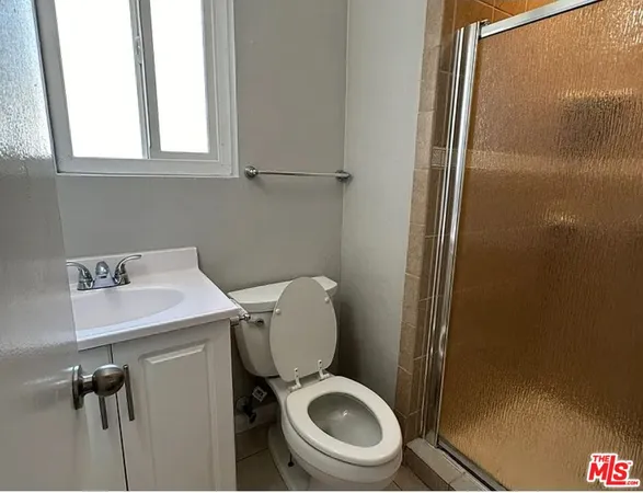 a white toilet sitting next to a bathroom sink