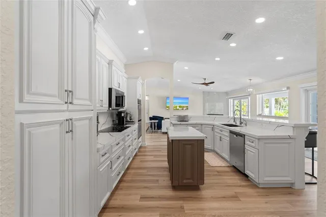 a kitchen with kitchen island a sink appliances and cabinets