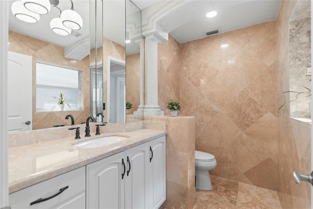 11391 Sundance Lane Boca Raton, FL 33428 - Photo 16 of 58 a bathroom with a granite countertop sink a toilet and a mirror