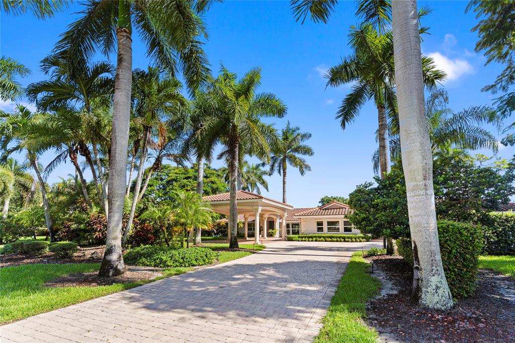 11391 Sundance Lane Boca Raton, FL 33428 - Photo 2 of 58 a front view of a house with a yard and palm trees