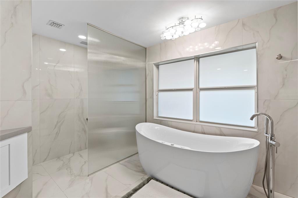 11391 Sundance Lane Boca Raton, FL 33428 - Photo 22 of 58 a bathroom with a bathtub and shower