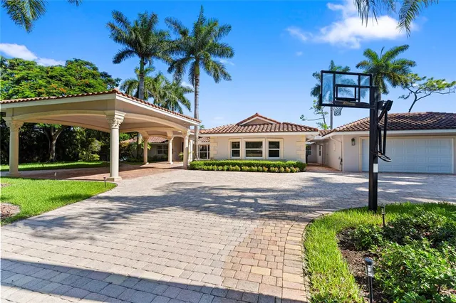 a view of a house with a yard and palm trees