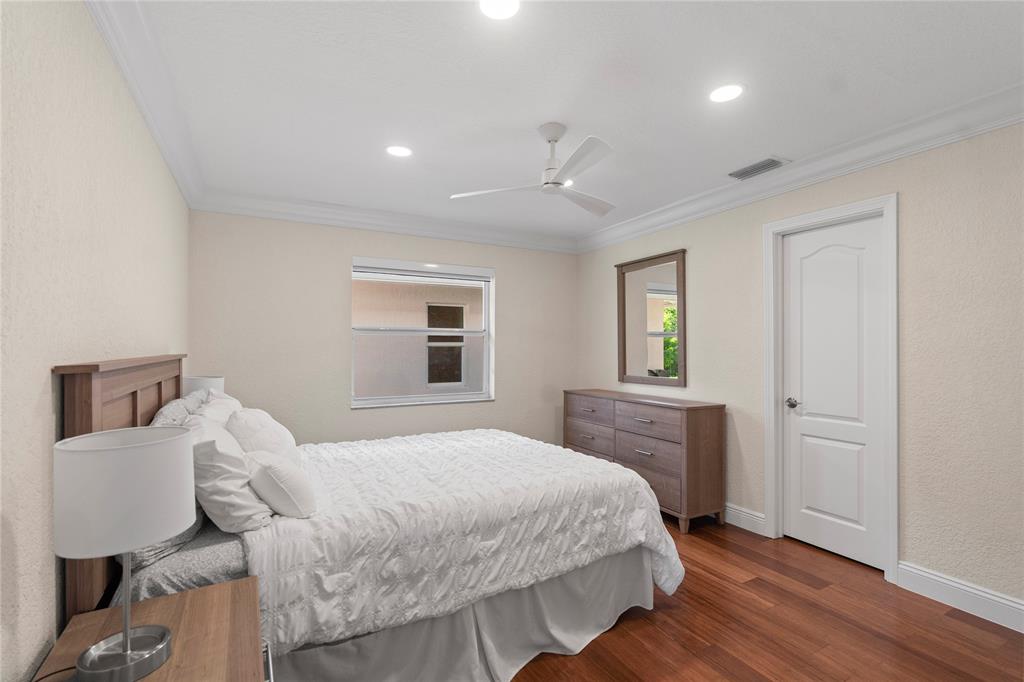 11391 Sundance Lane Boca Raton, FL 33428 - Photo 41 of 58 a bedroom with a bed and wooden floor