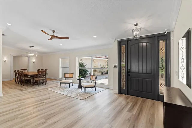 a living room with furniture a floor to ceiling window and wooden floor