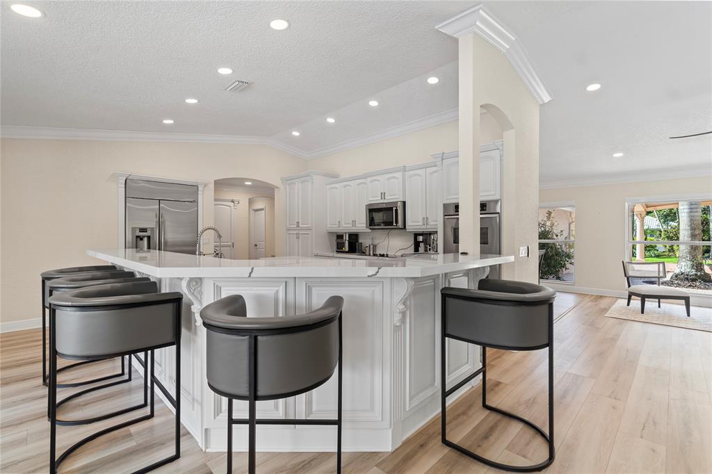 11391 Sundance Lane Boca Raton, FL 33428 - Photo 10 of 58 a kitchen with stainless steel appliances kitchen island granite countertop a stove a sink a dining table and chairs