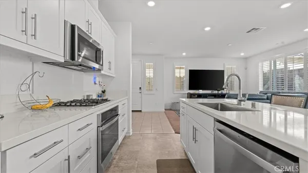 a kitchen with stainless steel appliances granite countertop a sink and a stove