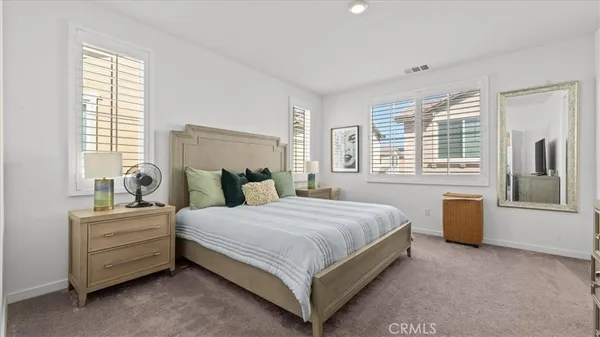a bedroom with a bed and a dresser next to a window