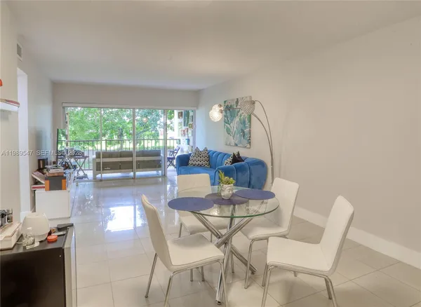a dining room with furniture and a floor to ceiling window