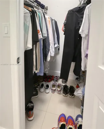 a view of walk in closet with clothes and shoes