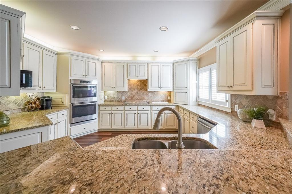 2502 Oak Hill Overlook Duluth, GA 30097 - Photo 14 of 34 a kitchen with granite countertop a sink a counter top space appliances and cabinets