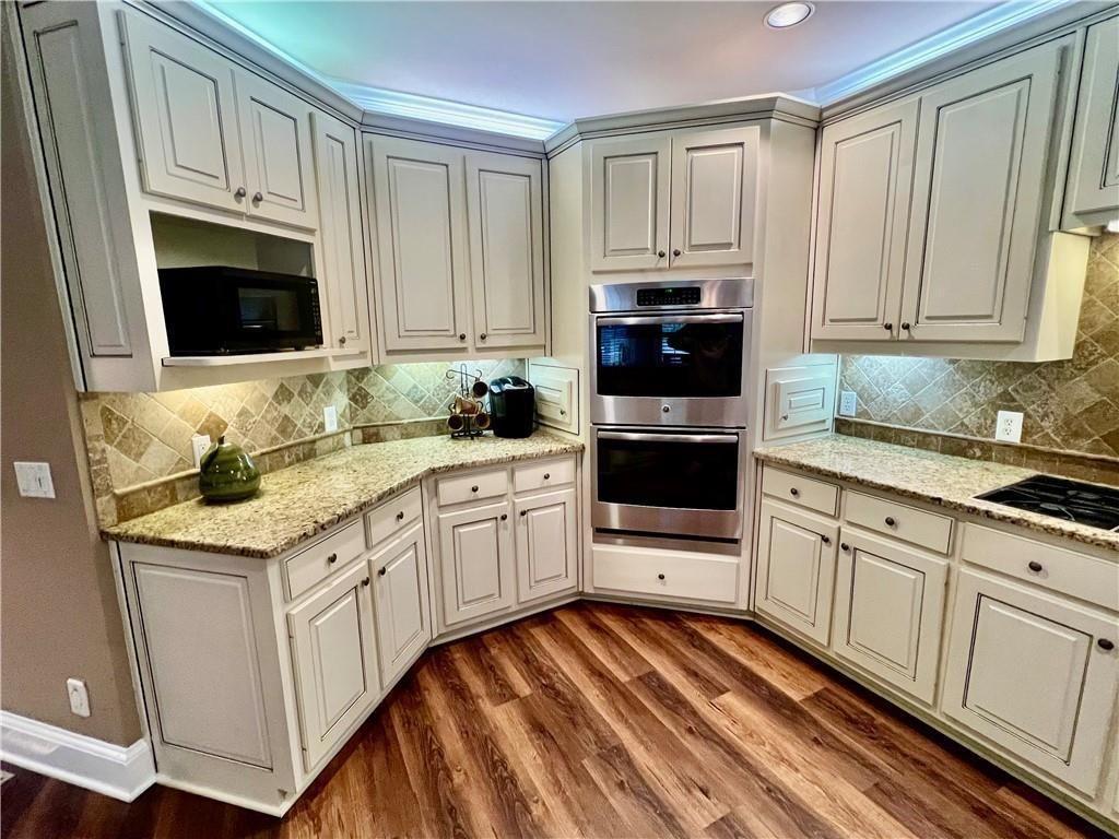 2502 Oak Hill Overlook Duluth, GA 30097 - Photo 15 of 34 a kitchen with granite countertop white cabinets and stainless steel appliances