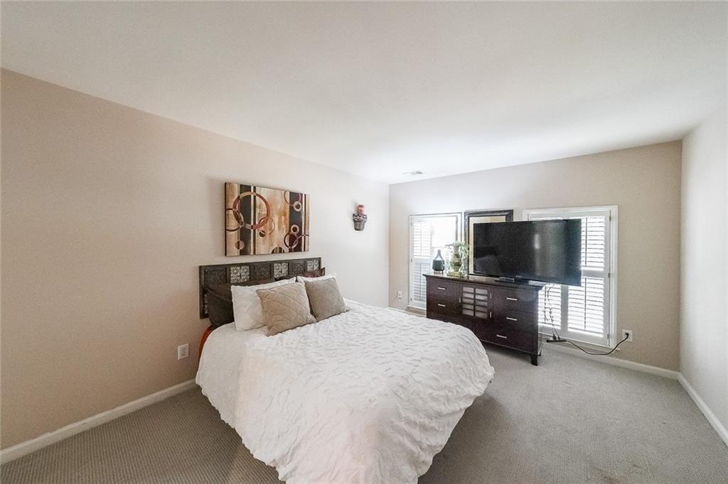 2502 Oak Hill Overlook Duluth, GA 30097 - Photo 24 of 34 a bedroom with a bed and a flat screen tv