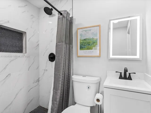 a bathroom with a shower a toilet and a sink