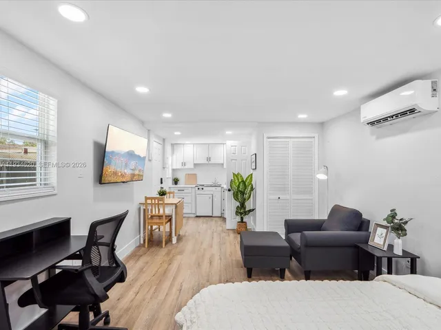 a living room with furniture wooden floor and a flat screen tv