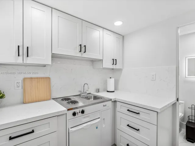 a kitchen with white cabinets and white appliances