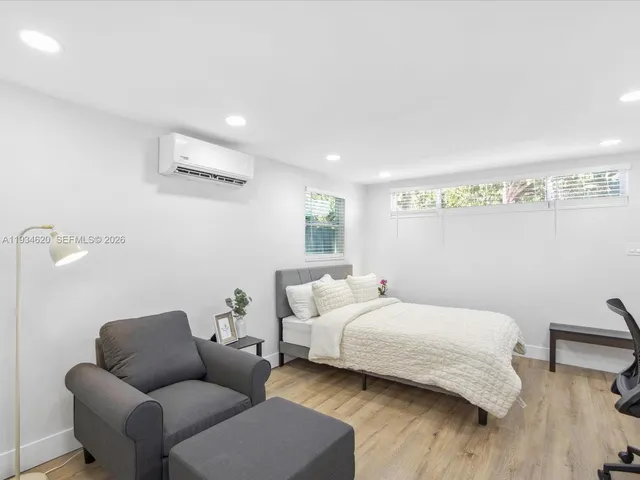 a bedroom with bed couch and window