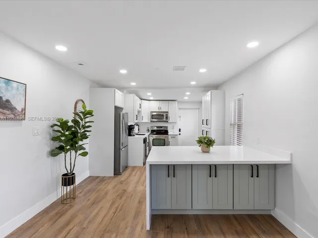 a living room with kitchen island furniture and a potted plant