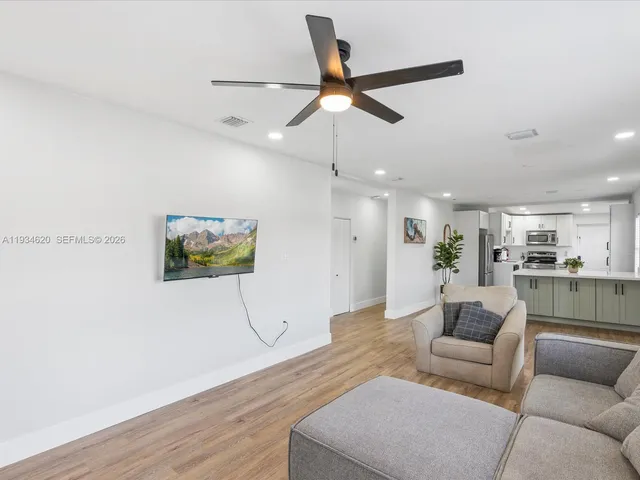 a living room with furniture and a ceiling fan