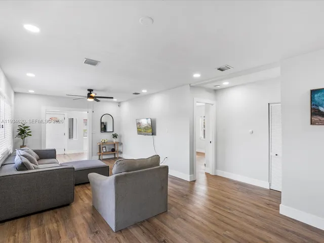 a living room with furniture and wooden floor