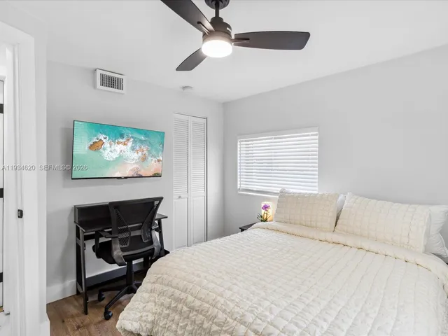 a bedroom with a bed and a flat screen tv