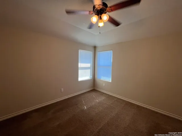 an empty room with a window and a fan