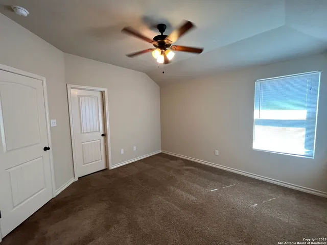 an empty room with closet and ceiling fan