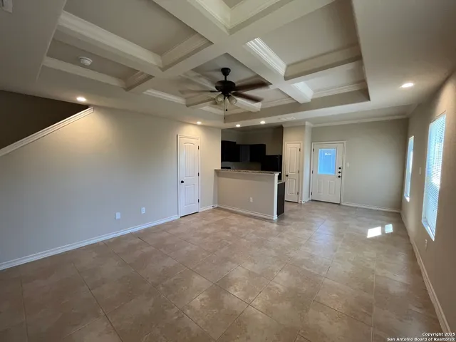 an empty room with fireplace and a ceiling fan