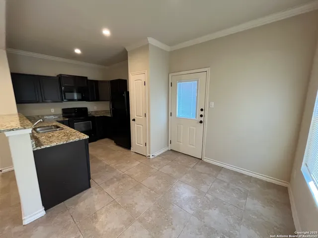 a view of kitchen with stainless steel appliances granite countertop a refrigerator and a stove top oven