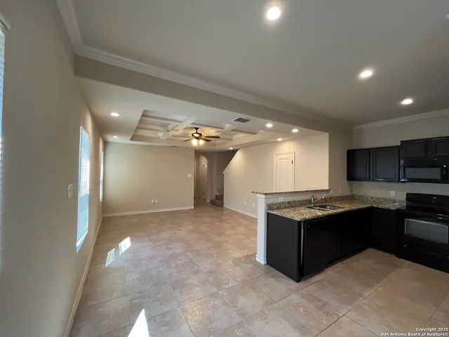 a kitchen with kitchen island granite countertop a sink and cabinets