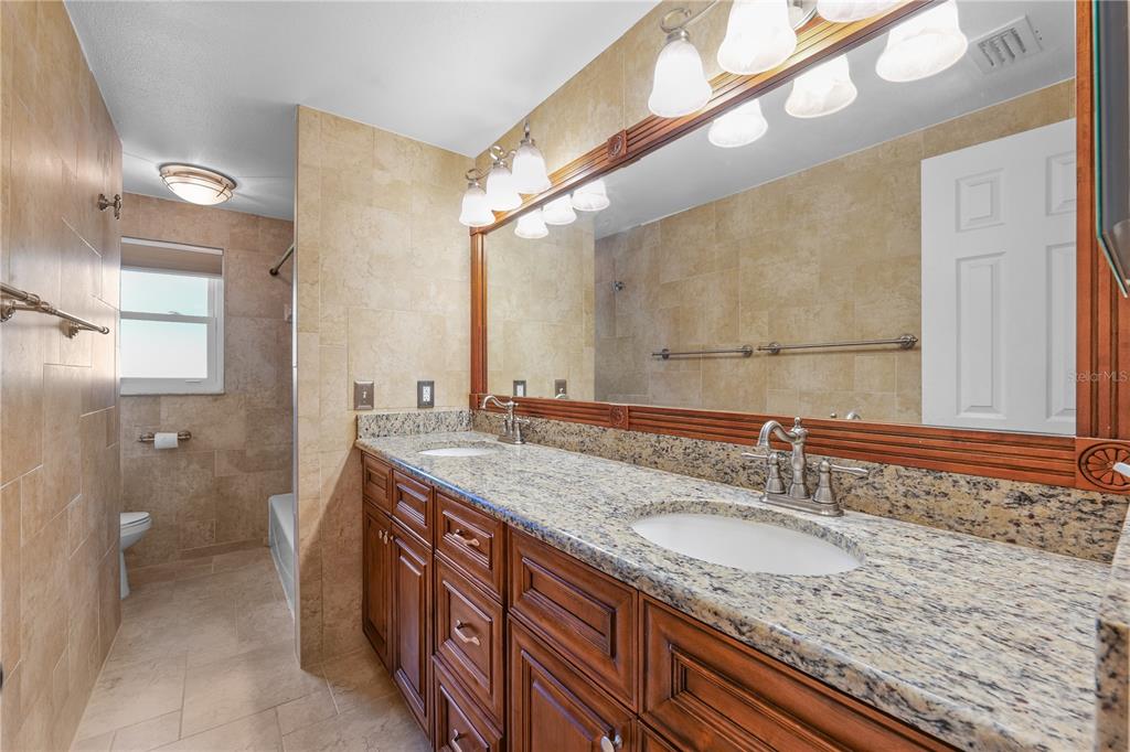 813 Druid Hills Road Temple Terrace, FL 33617 - Photo 20 of 30 a bathroom with a granite countertop sink and a mirror
