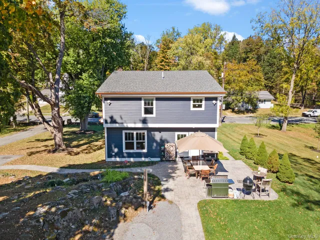 a front view of a house with garden and trees