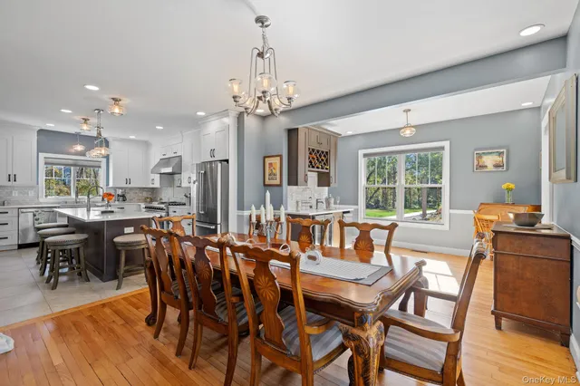 a kitchen with stove a refrigerator dining table and chairs