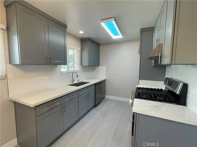 a kitchen with a sink a stove and cabinets