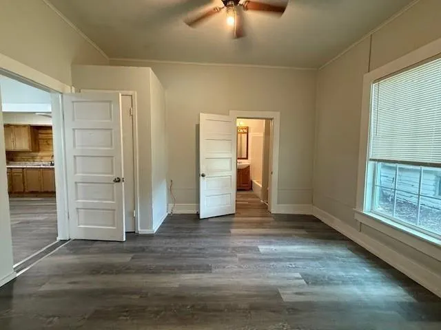 an empty room with closet and windows