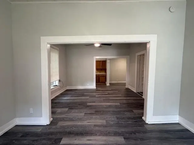 a view of an empty room with wooden floor and closet