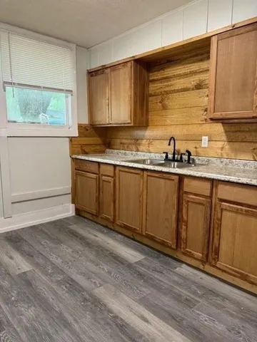 a kitchen with stainless steel appliances granite countertop a sink a stove cabinets and wooden floor