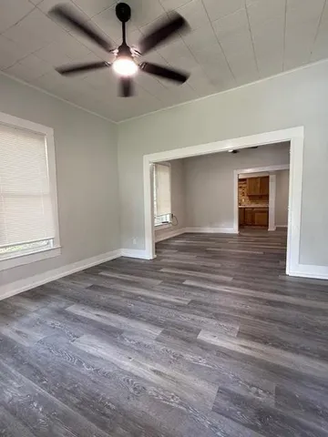 a view of a livingroom with a ceiling fan window and wooden floor