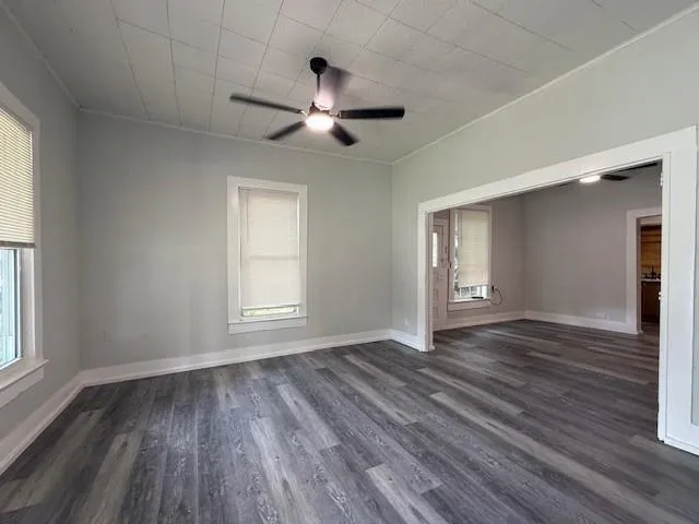 a view of empty room with wooden floor and fan
