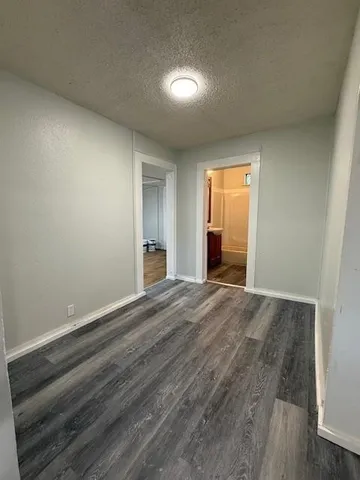 a view of an empty room and window and wooden floor
