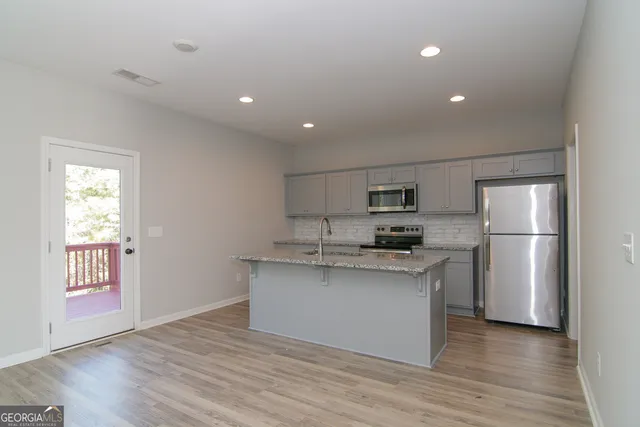 a kitchen with a sink a stove and cabinets