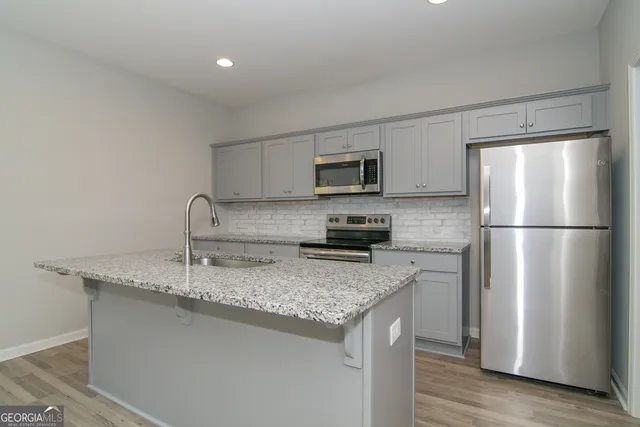 a kitchen with granite countertop a sink a microwave and stove