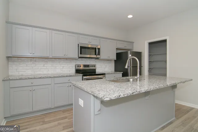a kitchen with granite countertop a sink and a stove top oven