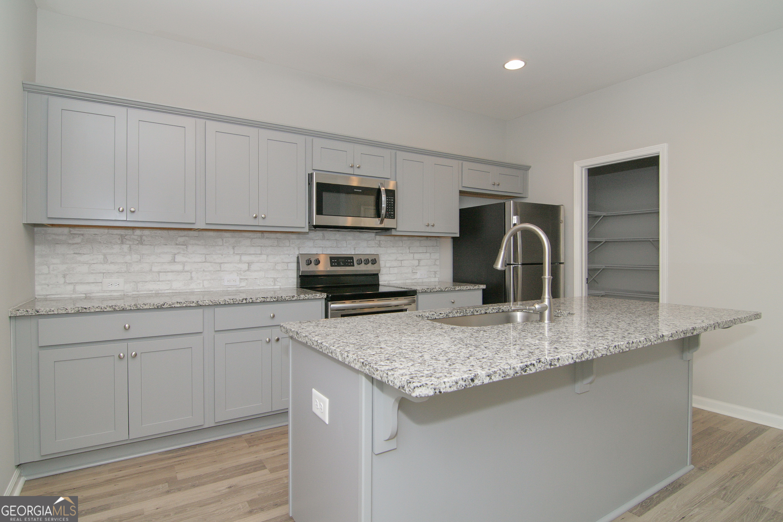 386 Springwater Way Bremen, GA 30110 - Photo 20 of 64 a kitchen with kitchen island granite countertop a sink a stove a microwave and refrigerator