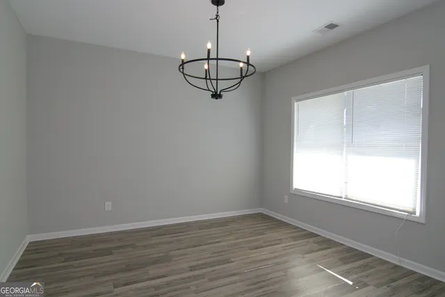 a view of a room with wooden floor and white walls